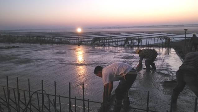 迎著朝霞，工人正在進行收尾工作